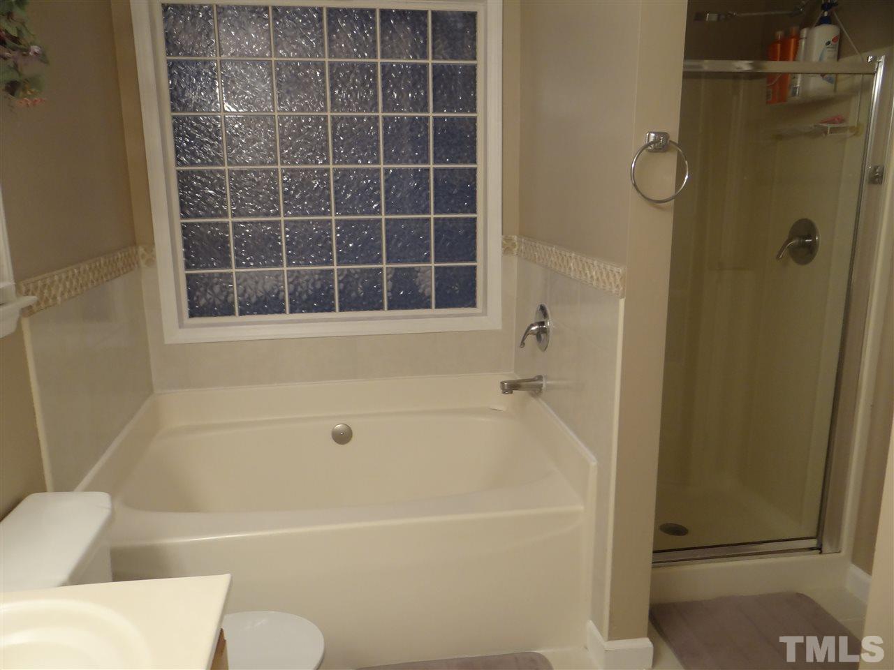 4208 Wolftrap Road Raleigh, NC 27616 - Photo 17 of 23 a bathroom with a bathtub and a shower