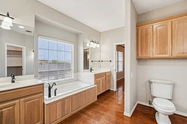 a bathroom with a granite countertop sink a toilet and bathtub