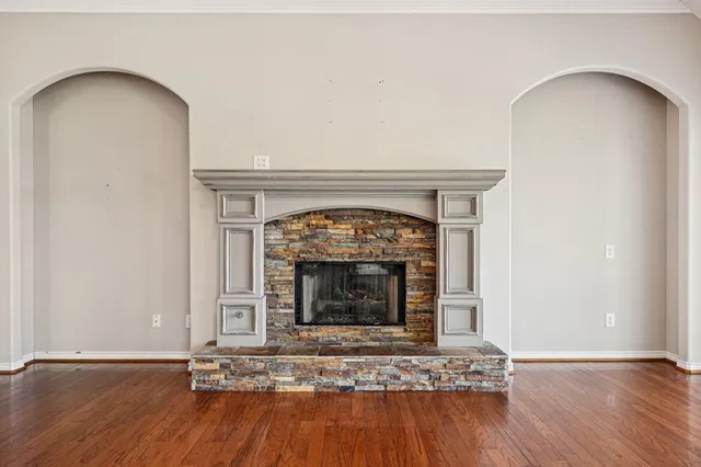 a living room with wooden floor and a fireplace