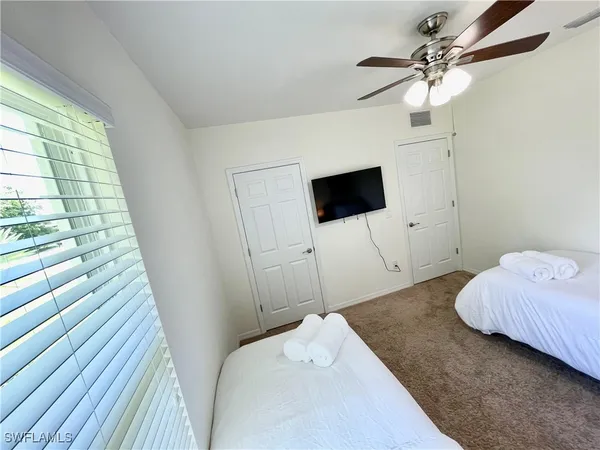 a bedroom with a bed and a flat tv screen on dresser