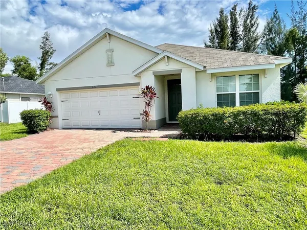 a front view of a house with a yard and garage