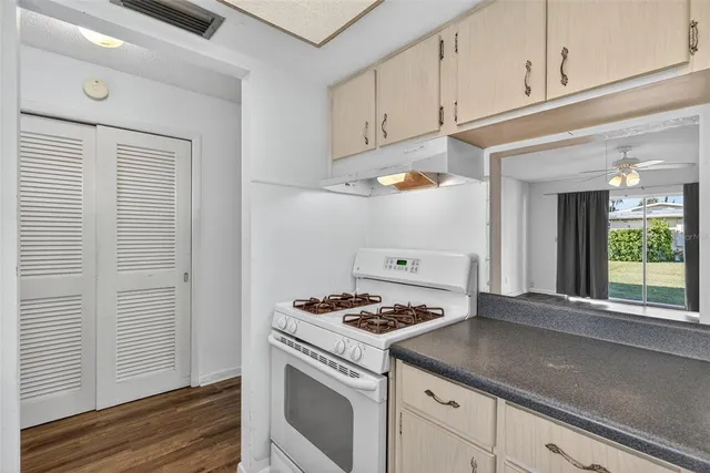 a kitchen with granite countertop cabinets stainless steel appliances and a wooden floor