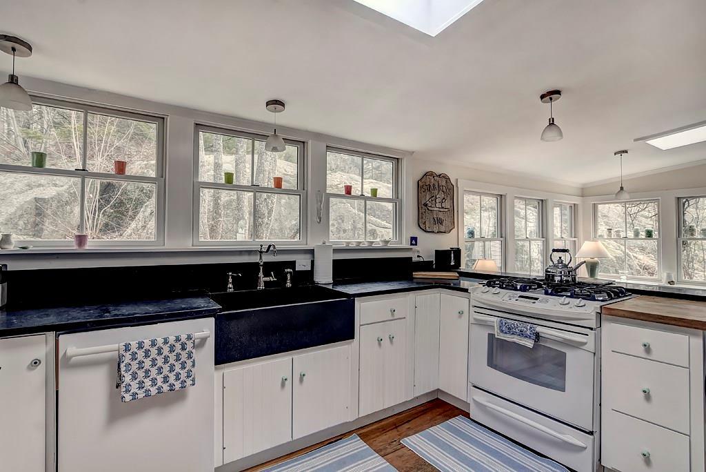Kitchen has large stone farmhouse...