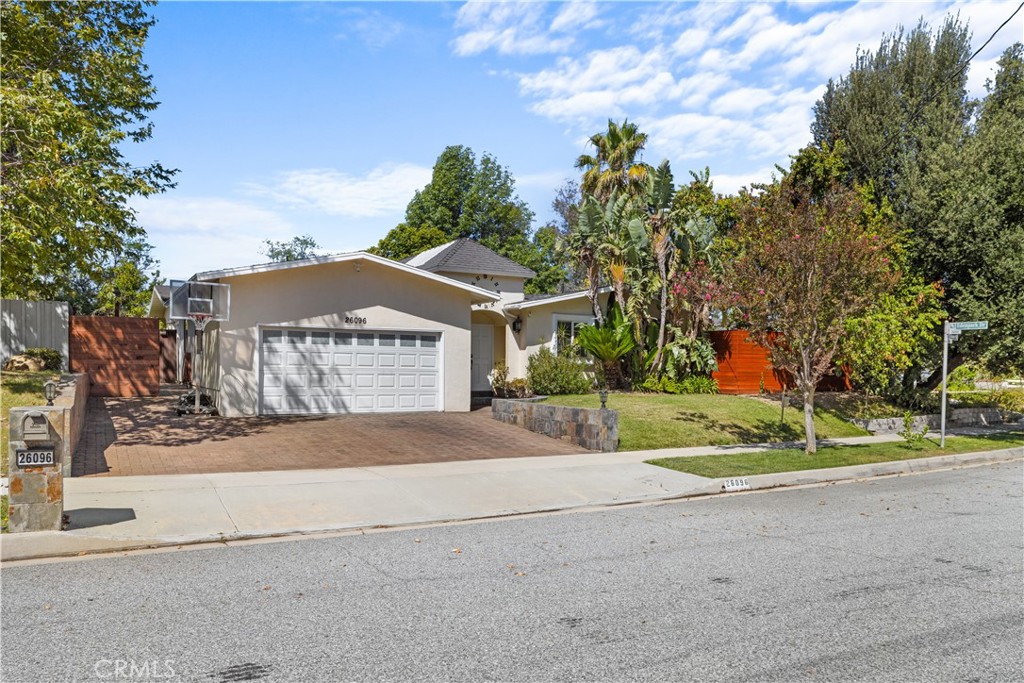 26096 Adamor Road Calabasas, CA 91302 - Photo 3 of 61 Streetview with illuminated mailbox numbers, 3-car wide driveway, basketball hoop, slate retaining walls and post lights on both sides. The redwood fence to the right has an oak tree growing through it with a hidden secret door.