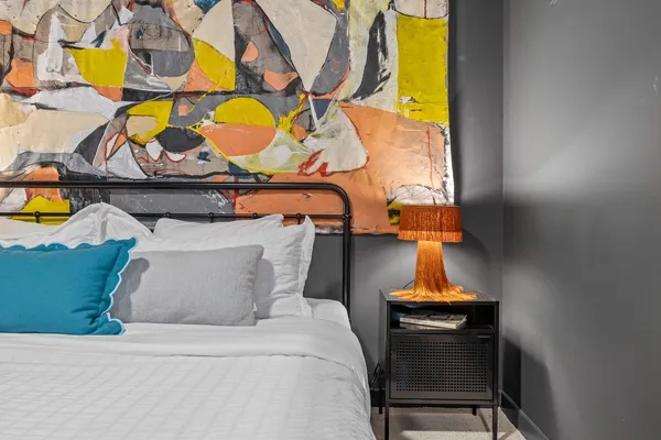 a bedroom with a bed and wall painting