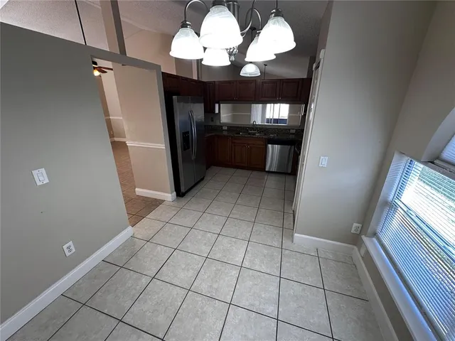 a kitchen with granite countertop a refrigerator stove and microwave