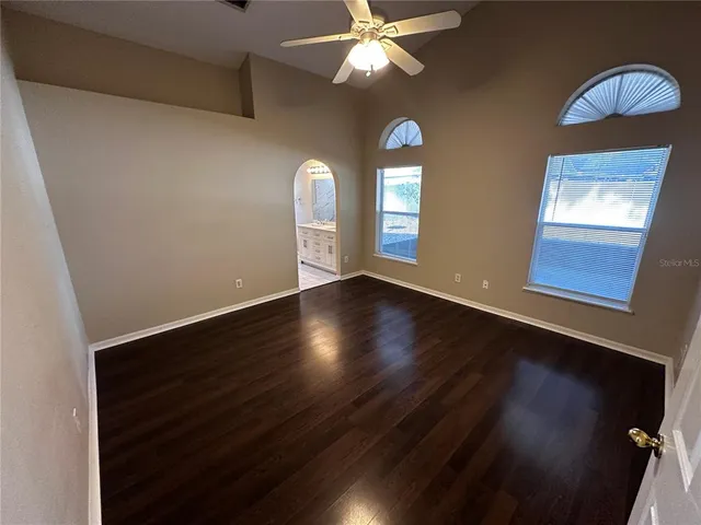 a view of a room with wooden floor and a ceiling fan