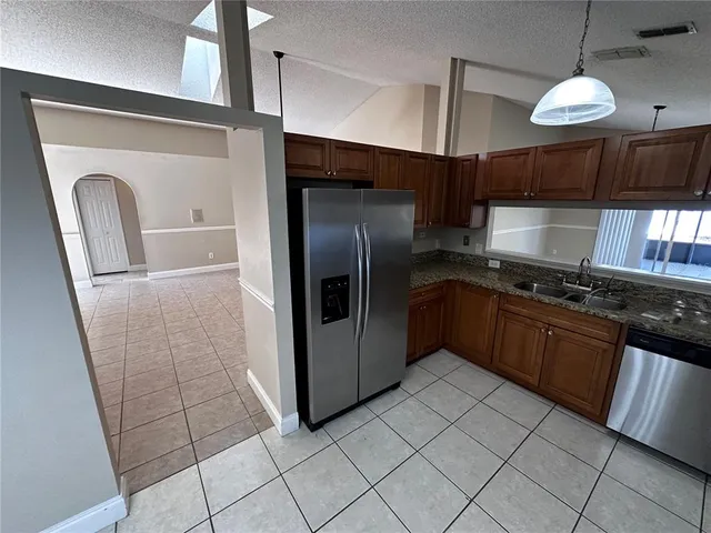 a kitchen with stainless steel appliances granite countertop a refrigerator a sink and a stove