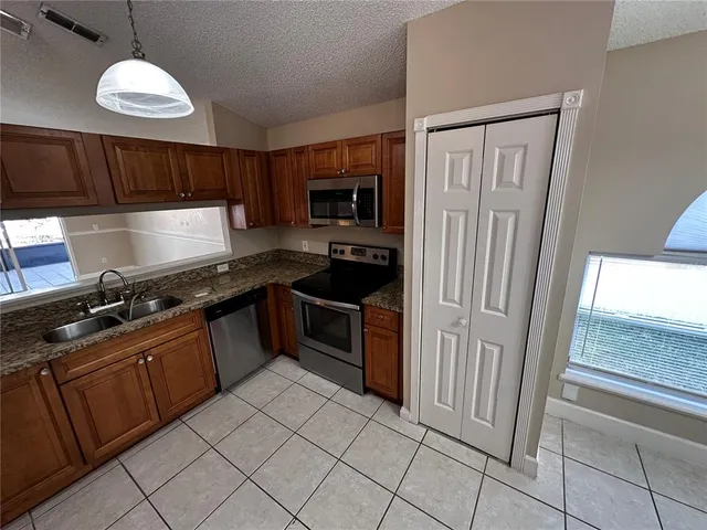 a kitchen with stainless steel appliances granite countertop a refrigerator and a sink