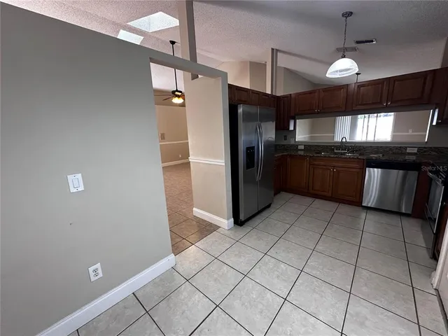 a kitchen with stainless steel appliances granite countertop a refrigerator and a sink