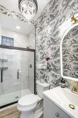 a bathroom with a sink a toilet and shower