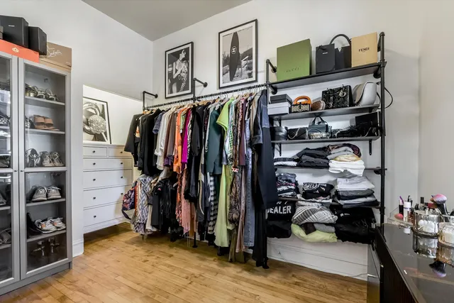 a view of walk in closet with clothes and shoes