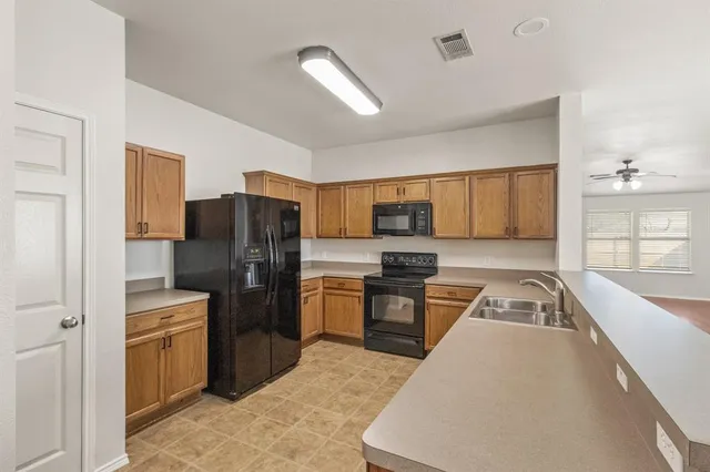 a kitchen with stainless steel appliances granite countertop a refrigerator stove and sink