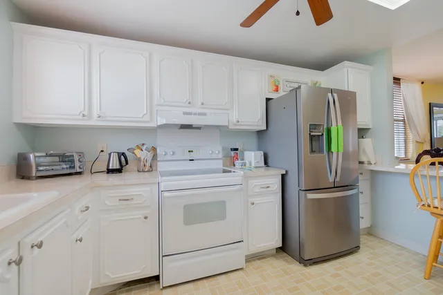 a kitchen with stainless steel appliances a refrigerator sink and cabinets