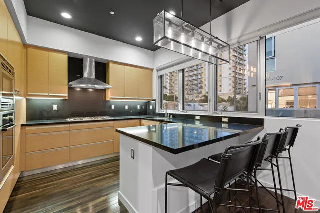 a kitchen with a sink a counter and chairs