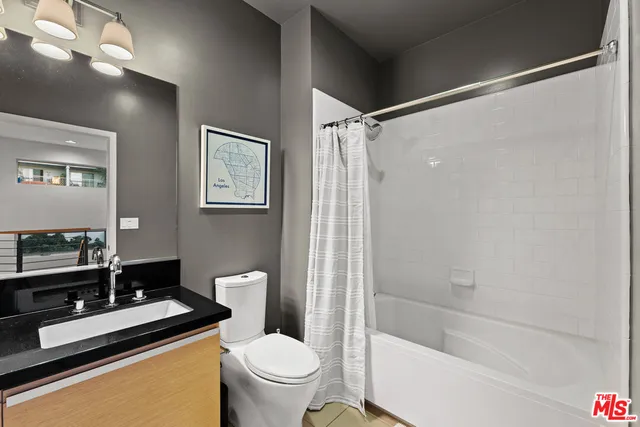 a bathroom with a granite countertop sink toilet and shower