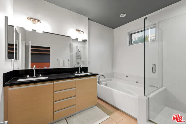 a bathroom with a granite countertop sink mirror and a bathtub