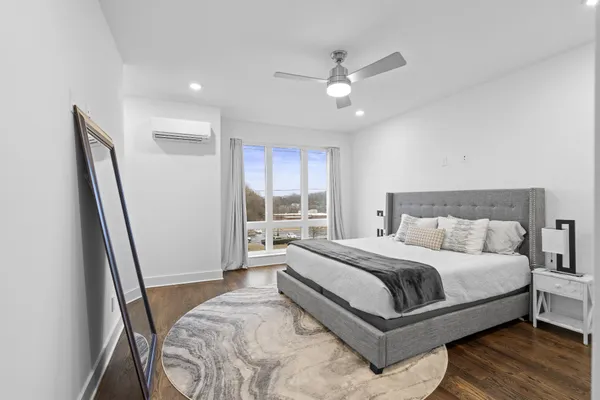 a bedroom with a bed lamp and a large window