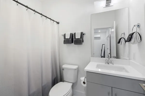 a bathroom with a sink a toilet and shower curtain