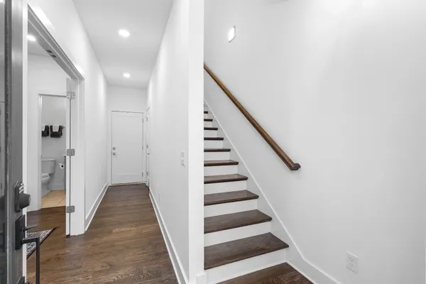 a view of a hallway with wooden floor and entryway