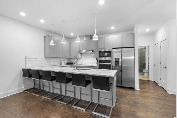 a kitchen with kitchen island a sink stove and refrigerator