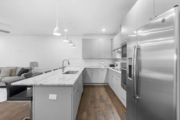 a kitchen with white cabinets a sink and stainless steel appliances