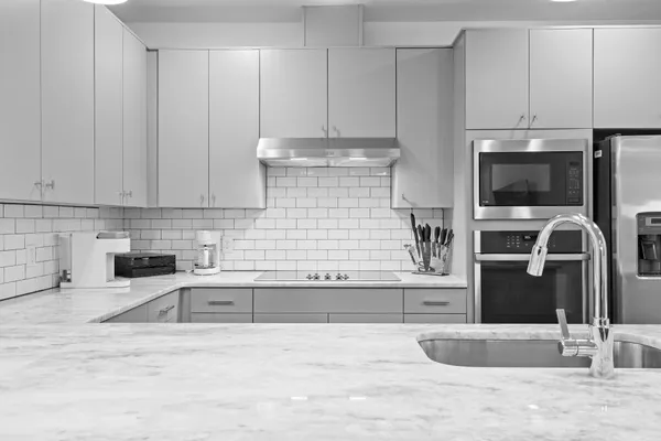 a kitchen with stainless steel appliances granite countertop a refrigerator and a stove top oven