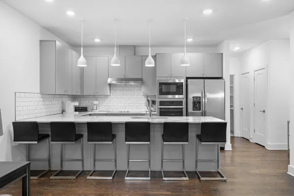 a kitchen with stainless steel appliances kitchen island granite countertop a sink and cabinets