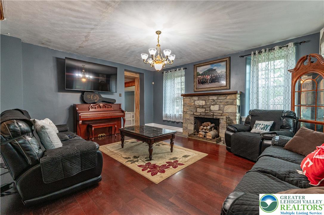 2485 Hieter Road Quakertown, PA 18951 - Photo 4 of 97 Rich hardwood floors complement a robust stone fireplace, anchoring this comfortable gathering space.