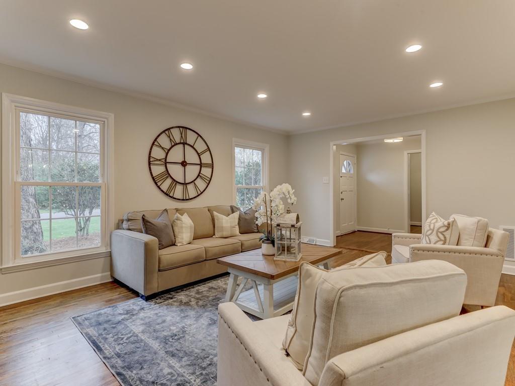 4234 Chevington Road Charlotte, NC 28226 - Photo 7 of 46 a living room with furniture a large window and a clock