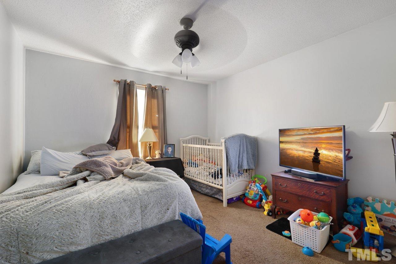 4541 Hargrove Road Raleigh, NC 27604 - Photo 16 of 24 a bedroom with a bed and a chandelier