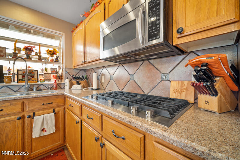 2215 Gatewood Drive Reno, NV 89523 - Photo 17 of 37 a kitchen with granite countertop a sink and a stove next to a window
