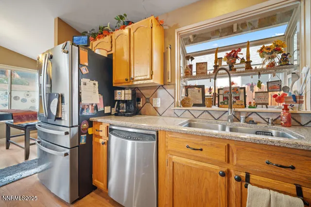 a kitchen with stainless steel appliances granite countertop a sink and a refrigerator