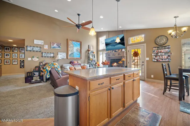 a kitchen with stainless steel appliances granite countertop a sink dishwasher and a dining table with wooden floor