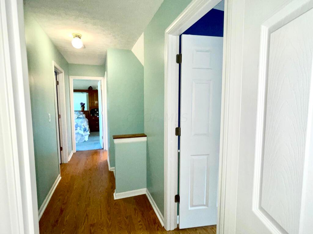5294 Bressler Drive Hilliard, OH 43026 - Photo 19 of 45 Looking down the hallway from bedroom 4 to the primary suite. Door on the right is to bedroom 3. door on the left is bedroom 2.