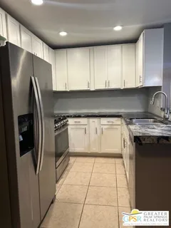 a kitchen with stainless steel appliances granite countertop a stove a refrigerator and a sink