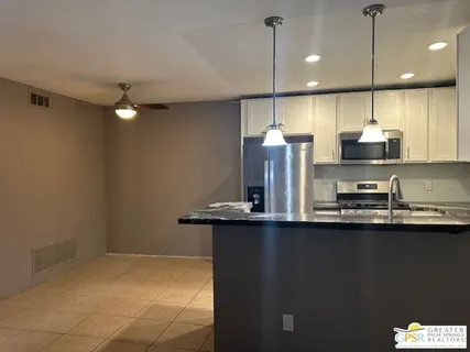 a kitchen with stainless steel appliances granite countertop a sink a stove and a refrigerator