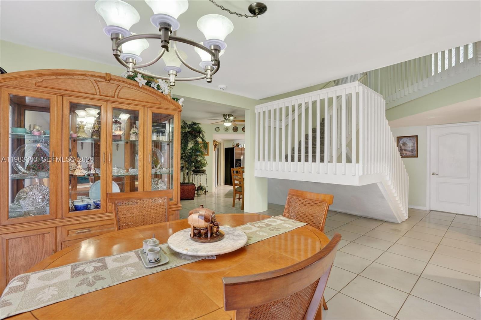 15672 Southwest 91st Lane Miami, FL 33196 - Photo 13 of 47 a view of a dining room with furniture wooden floor and chandelier