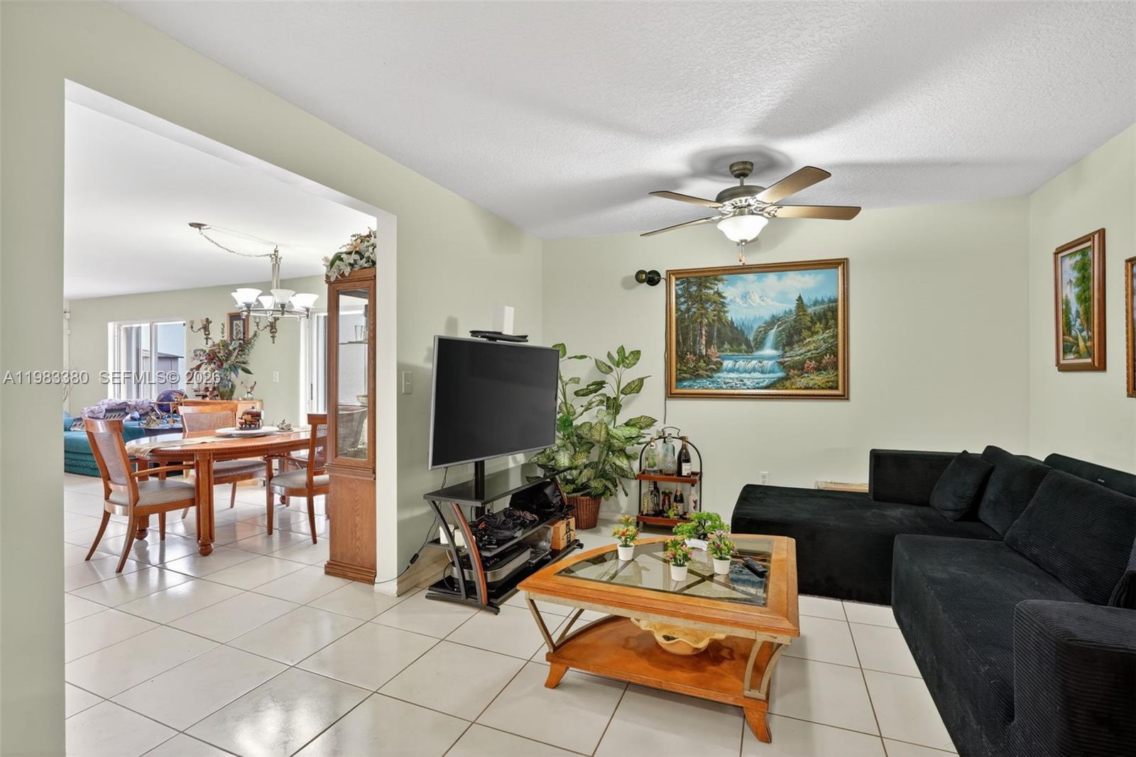 15672 Southwest 91st Lane Miami, FL 33196 - Photo 16 of 47 a living room with furniture a flat screen tv and a window