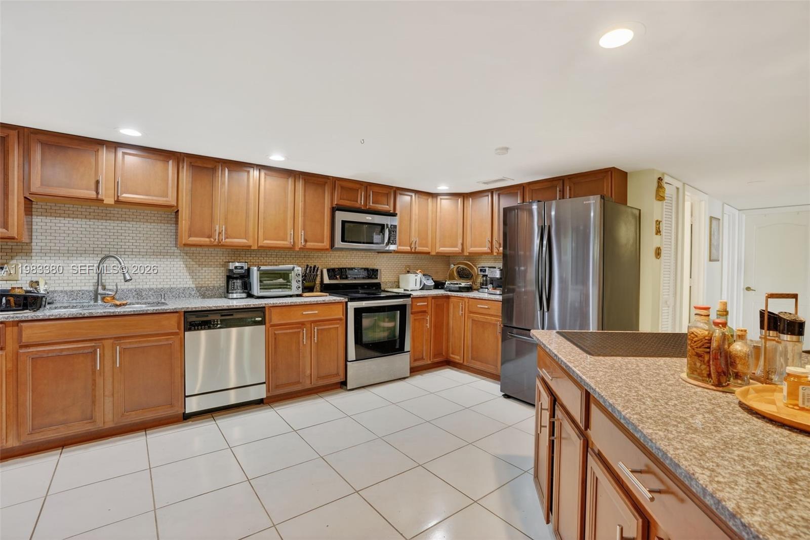 15672 Southwest 91st Lane Miami, FL 33196 - Photo 18 of 47 a kitchen with granite countertop a sink cabinets and stainless steel appliances