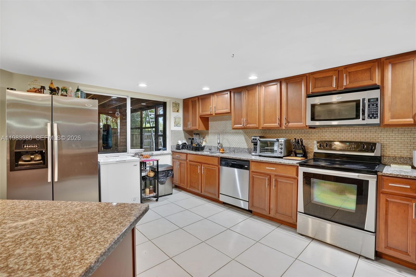 15672 Southwest 91st Lane Miami, FL 33196 - Photo 19 of 47 a kitchen with stainless steel appliances granite countertop a refrigerator sink and stove