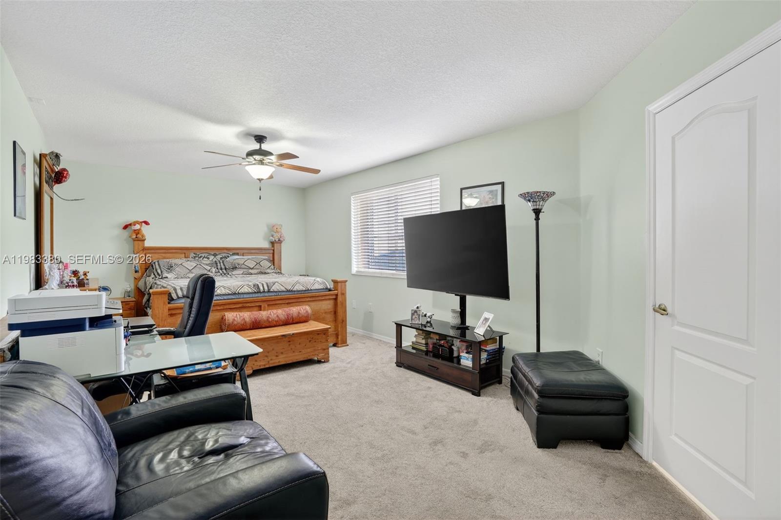 15672 Southwest 91st Lane Miami, FL 33196 - Photo 26 of 47 a bedroom with furniture and a flat screen tv