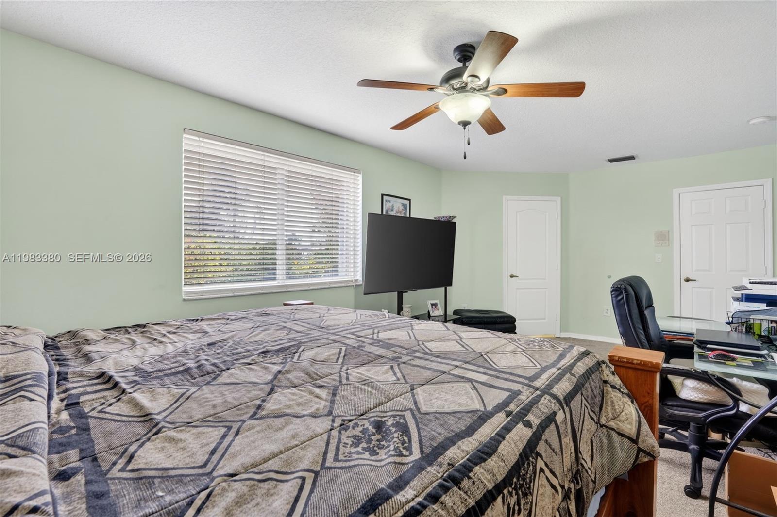 15672 Southwest 91st Lane Miami, FL 33196 - Photo 27 of 47 a bedroom with a bed and a flat screen tv