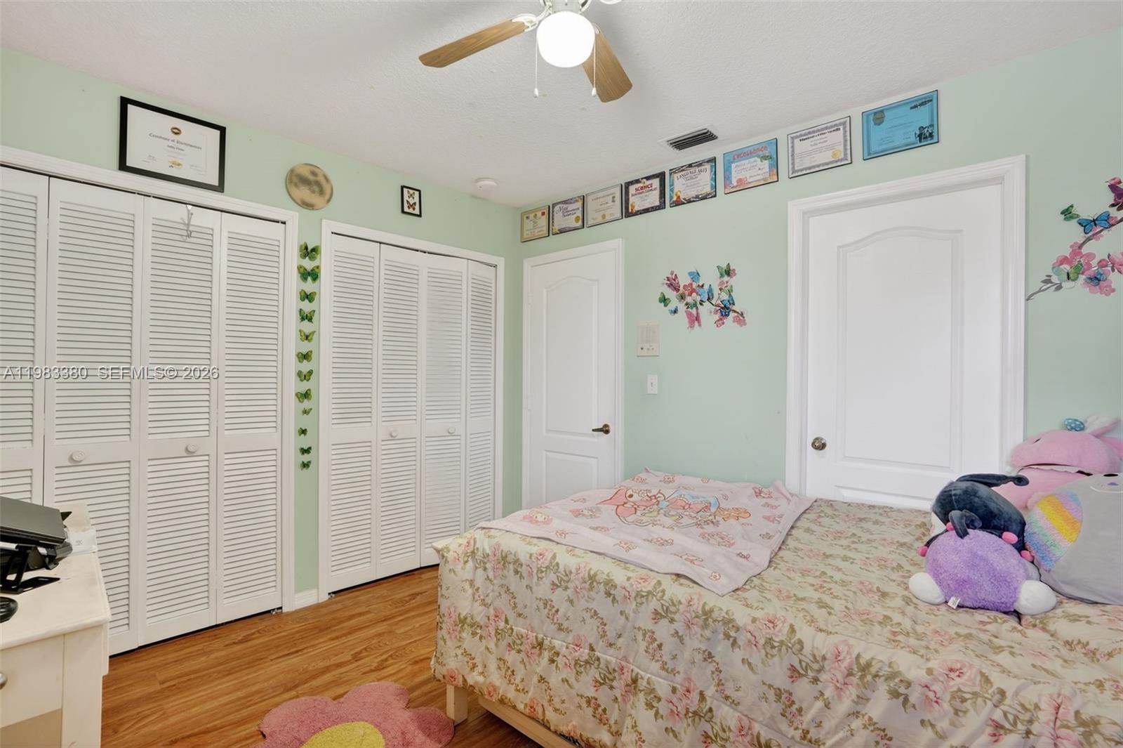 15672 Southwest 91st Lane Miami, FL 33196 - Photo 36 of 47 a bedroom with a bed and a chandelier