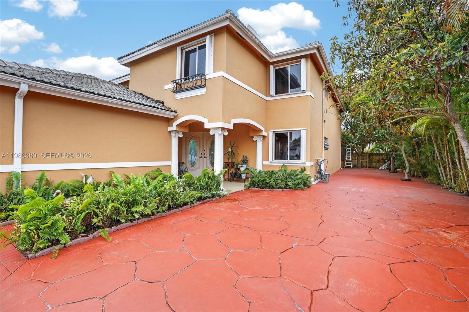 15672 Southwest 91st Lane Miami, FL 33196 - Photo 6 of 47 a front view of a house with garden