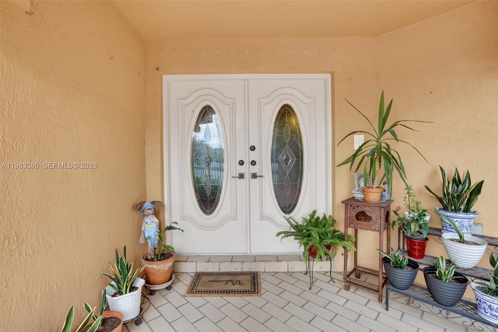 15672 Southwest 91st Lane Miami, FL 33196 - Photo 8 of 47 a view of a entryway with potted plants
