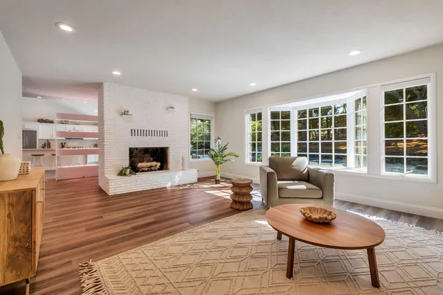 a view of a patio with couches chairs and wooden floor