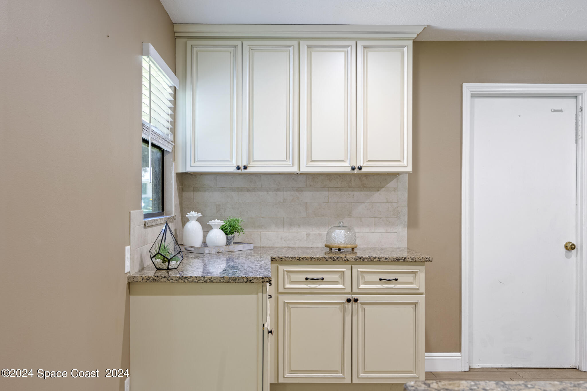 3725 Laurette Road Merritt Island, FL 32952 - Photo 17 of 46 a kitchen with stainless steel appliances white cabinets and a window
