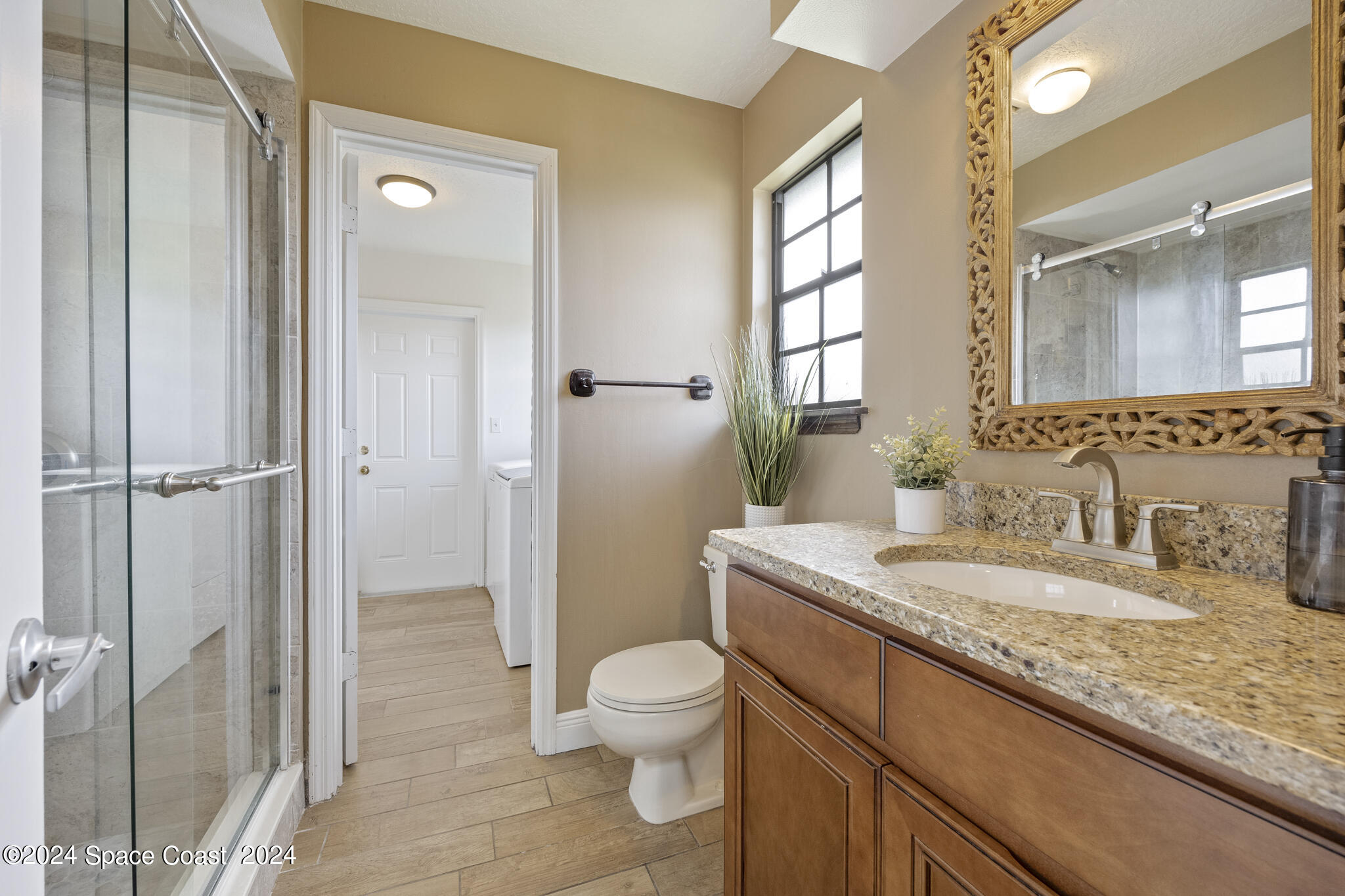 3725 Laurette Road Merritt Island, FL 32952 - Photo 26 of 46 a bathroom with a granite countertop sink toilet a mirror and shower