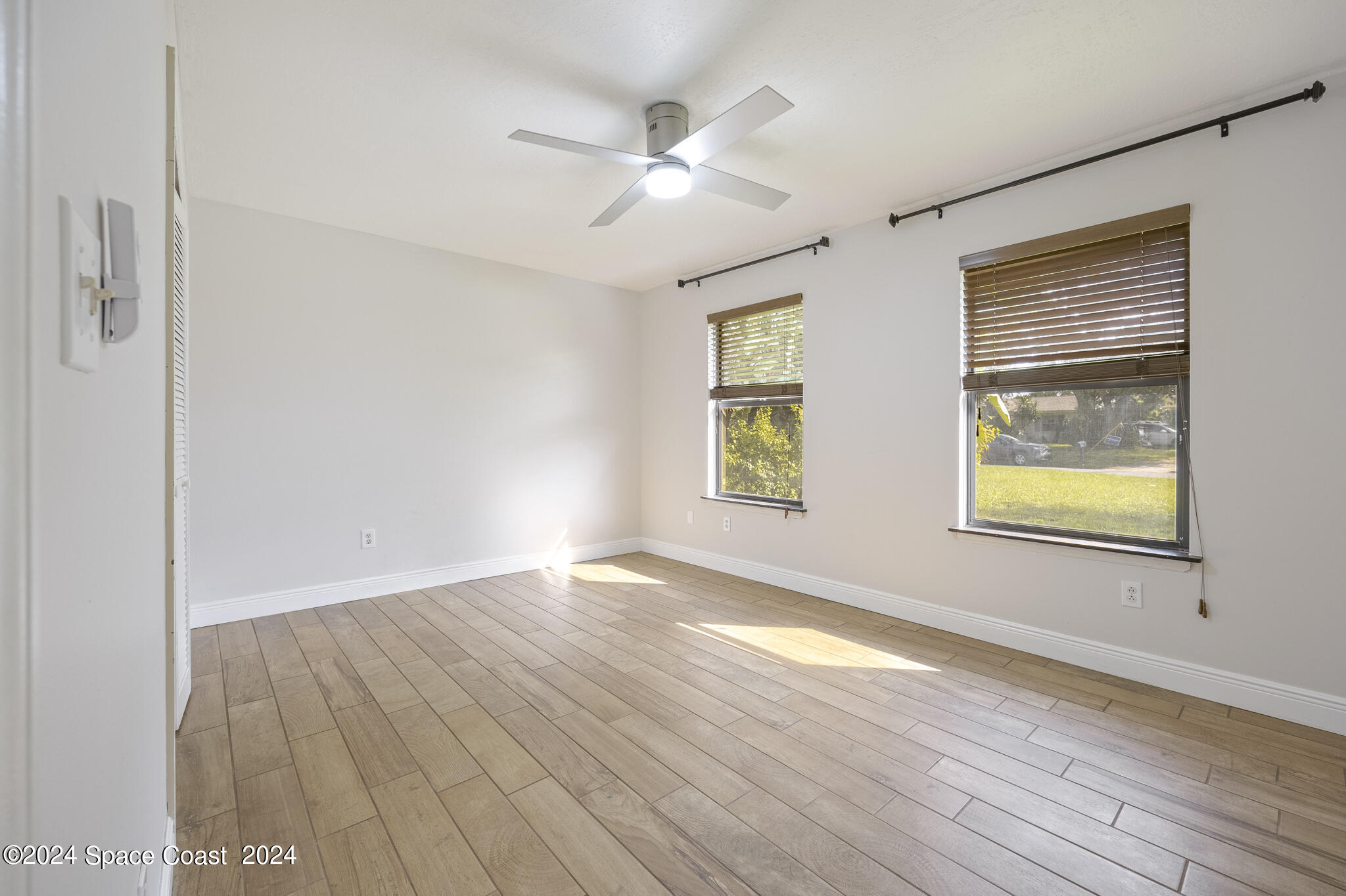 3725 Laurette Road Merritt Island, FL 32952 - Photo 28 of 46 an empty room with wooden floor and windows